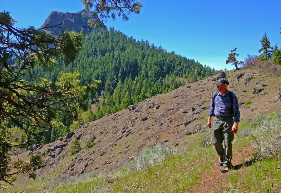 Hunter walking a high open slope toward the peaks